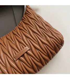 Close-up of caramel pleated leather texture with a Fashion & Bags label detail