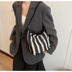 Close-up of black and white striped tote bag showing fine fabric texture and leather straps