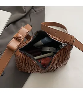 Internal view of brown pleated crossbody bag showing high capacity for daily essentials