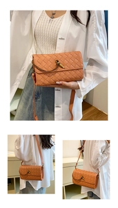 Close-up of woven orange leather crossbody bag featuring a golden knot metal clasp detail