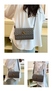 Detail of grey woven leather crossbody bag featuring a golden knot metal clasp closure