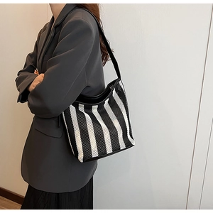 Detail of black and white striped woven shoulder bag with mesh texture and premium finish