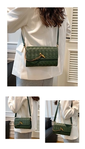 Detail of dark green woven crossbody bag featuring a golden knot buckle and slim strap