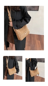Detail of khaki pleated crossbody bag with adjustable strap and metal hardware