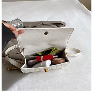 Detail shot of the spacious interior with a side zipper pocket in a white woven bag