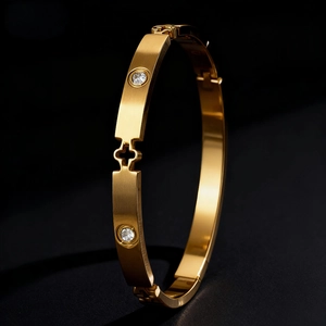Gold stainless steel bangle with four-leaf clover cutout and sparkling cubic zirconia