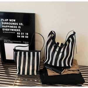 Detail of minimalist black and white striped knit tote and bucket bag set with leather straps