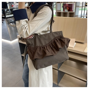 Detail of ruffle trim on a large coffee brown canvas tote bag with long shoulder straps