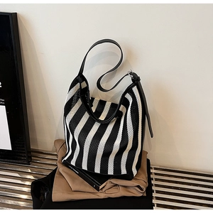 Close-up of black and white striped mesh tote bag with durable synthetic leather strap