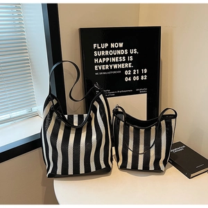 Detail of black and white striped knit tote bags with leather straps in two sizes