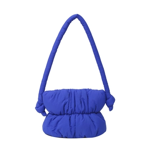 Royal blue quilted nylon bucket bag with a puffy texture and knotted shoulder strap