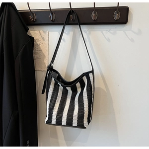 Detail of hobo shoulder bag featuring black and white stripes and mesh knit texture