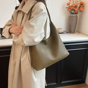 Olive green woven hobo shoulder bag with a large capacity shown on a shoulder