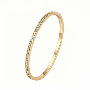 Detail of gold titanium steel bangle with double row of inlaid crystals and side clasp