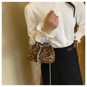 Close-up of leopard print bucket bag with silver metal handle and chain strap details