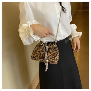 Detail of leopard print bucket bag with silver metal ring handle and chain strap