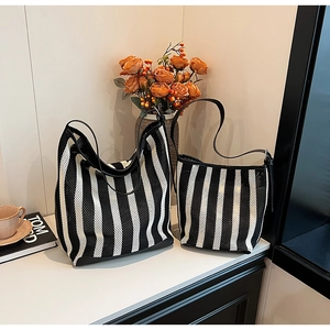 Detail view of striped tote bag set with black leather trim and breathable mesh texture