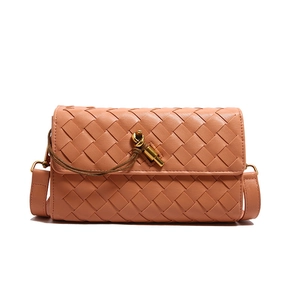 Peach pink woven leather crossbody bag with a decorative gold knot buckle and slim strap
