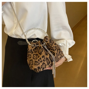 Detail of leopard print bucket bag featuring metal ring handle and fringe accents