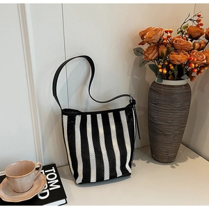 Detail of minimalist black and white striped shoulder bag with breathable mesh texture