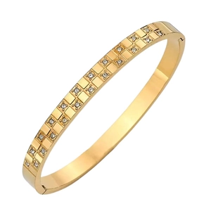 Polished gold checkered bangle with double row cubic zirconia inlays on white background