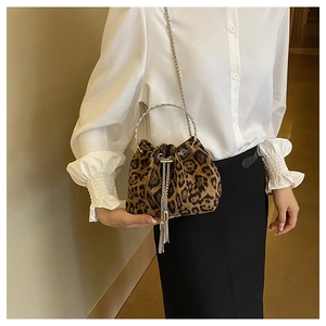 Close-up of leopard print bucket bag with silver ring handle and metal tassel drawstring