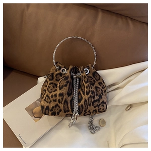 Detailed view of leopard print bucket bag with silver metal handle on leather background