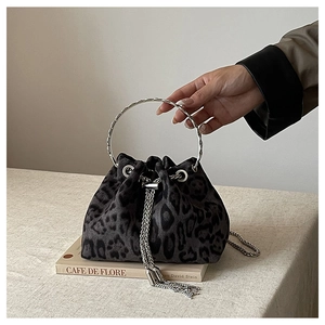 Close-up of leopard print bucket bag with silver metal ring handle and chain tassel