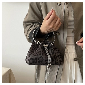 Detail of leopard print bucket bag with metal chain tassels and velvet texture
