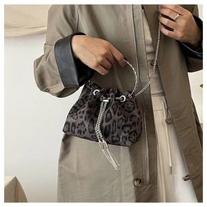 Detail of leopard print bucket bag with silver tassel and sleek metal ring handle