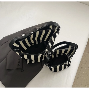 Detail of black and white striped woven tote set with leather handles and inner pouch