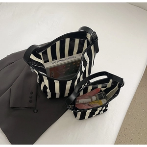 Detail of striped tote bags showing large capacity and black leather trim for daily use
