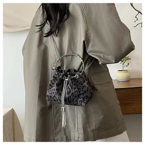 Detail of leopard print bucket bag with silver metal ring handle and chain strap