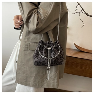 Detail of grey leopard print bucket bag with silver chain strap and metal fringe
