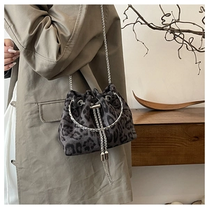 Detail of leopard print bucket bag featuring silver chain strap and tassel drawstring