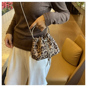 Detail of leopard print bucket bag featuring silver circular handles and a chain strap