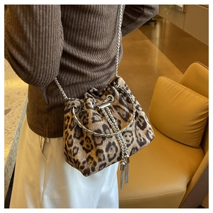 Leopard print bucket bag with metal chain strap worn by a model in a side-rear view