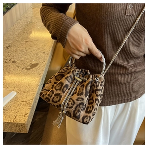Leopard print bucket bag with metal chain fringe detail shown as a crossbody