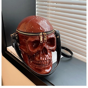 Détail du sac à main tête de mort rouge en cuir verni brillant avec double fermeture dorée