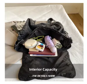 Spacious interior of black washed denim tote bag showing tablet and daily essentials
