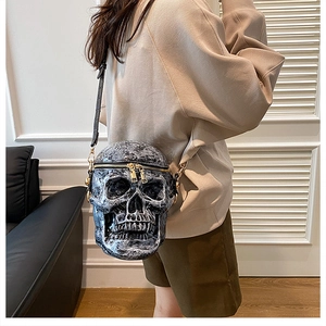 Détail du sac à bandoulière créatif en forme de crâne avec texture roche et zips dorés