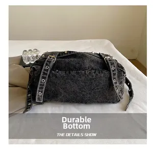 Macro detail of dark grey denim tote bag with silver eyelets and wear-resistant bottom