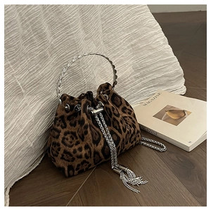 Close-up of leopard print bucket bag with silver ring handle and chain tassels