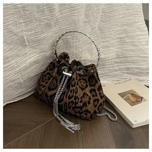 Close-up of leopard print bucket bag with silver metal ring handle and chain tassel detail