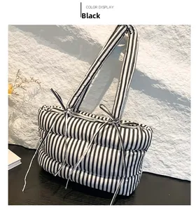 Détail du sac cabas matelassé à rayures noires et blanches avec nœuds décoratifs