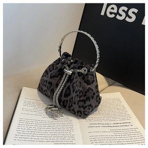Macro view of leopard print bucket bag with ornate silver round handle and tassel