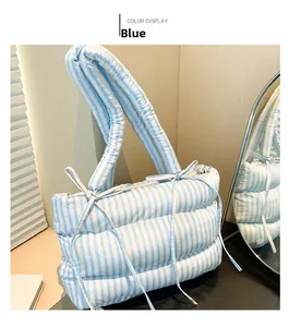 Détail du sac cabas matelassé à rayures bleues et blanches avec un nœud décoratif