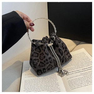 Close-up of leopard print bucket bag with metal handle and chain tassel detail