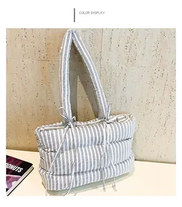 Détail d'un sac cabas matelassé à rayures avec des nœuds et une texture rembourrée