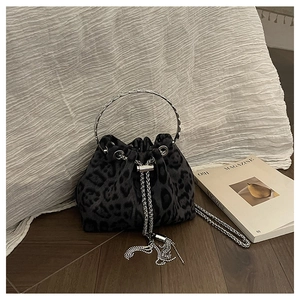 Detail of dark grey leopard print bucket bag with silver metal ring handle and tassel
